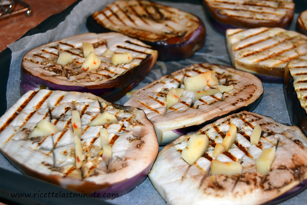 Cooked aubergines, carved with provolone