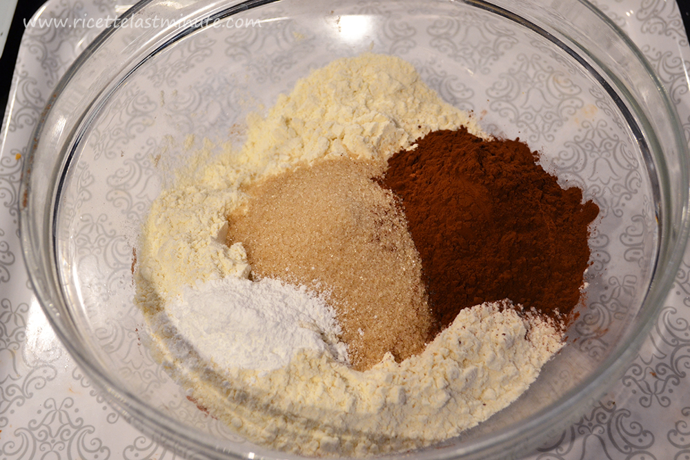 Ciotola con dentro la farina, il lievito, lo zucchero e il cacao