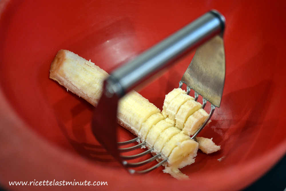 Banana matura in fase di schiacciamento con una frusta per impasti