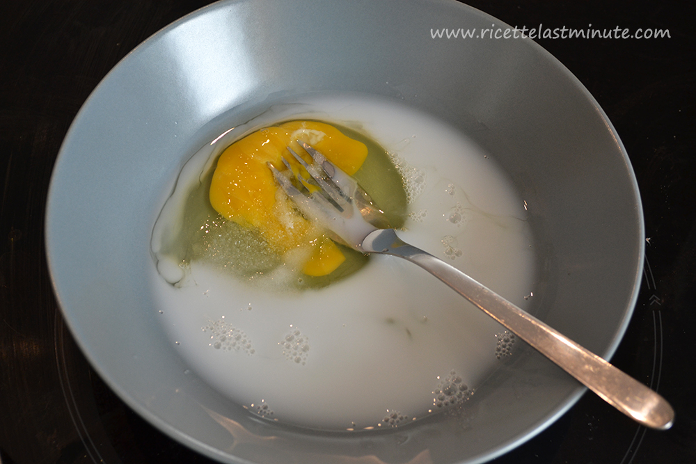Aggiunta del latte nella ciotola con uovo e zucchero