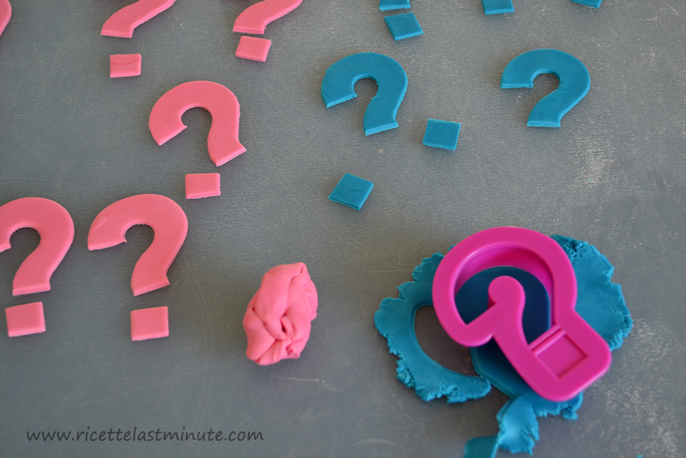 Punti interrogativi fatti con la pasta di zucchero sia rosa che azzurra
