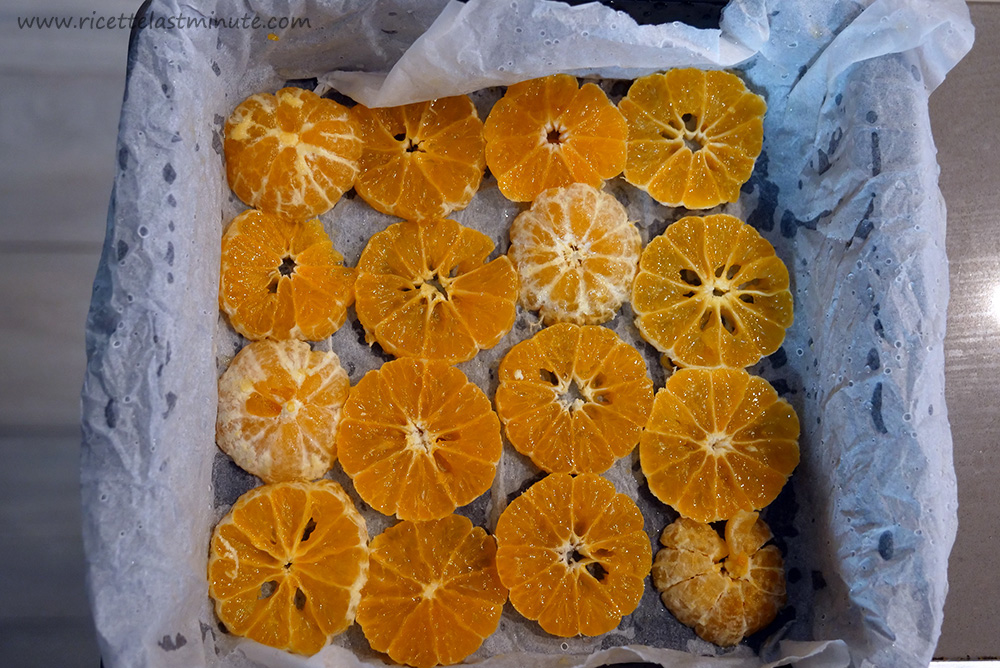 Mandarini tagliati a fettine e posizionati in fondo alla teglia quadrata
