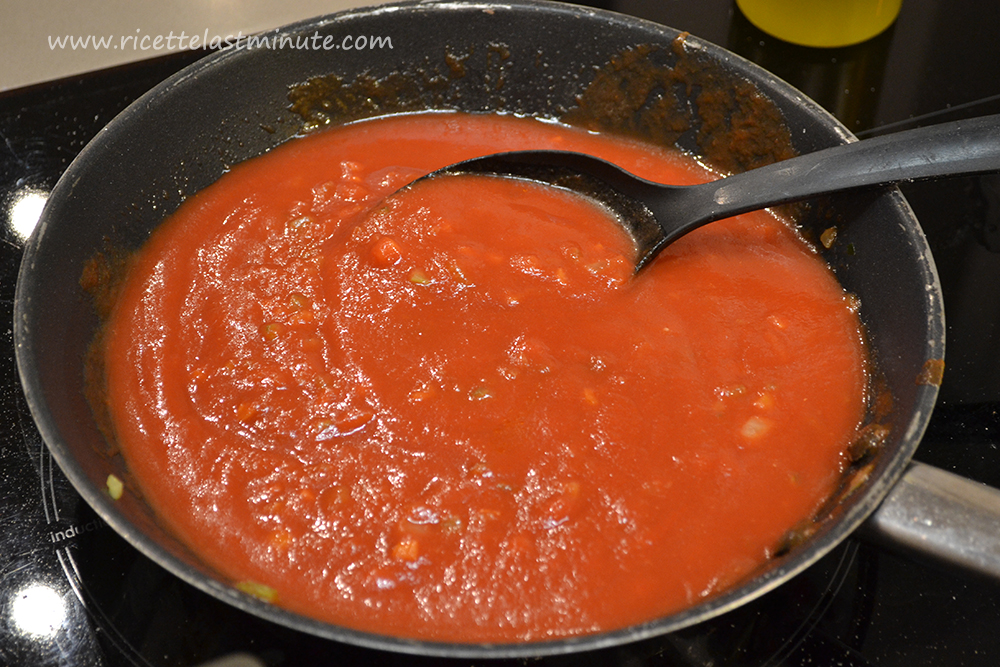 Aggiunta di salsa di pomodoro nel mix per soffritto