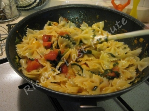 Cottura della pasta con rucola, pomodorini e cipolla